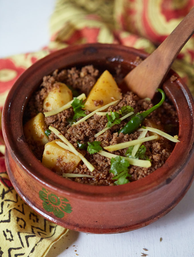 Keema Aloo in a clay handi garnished with coriander and ginger